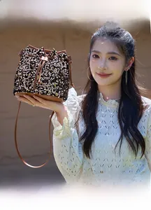 Détail du sac seau à paillettes avec cordon en cuir marron et fine bandoulière en cuir