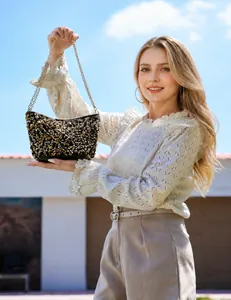 Detail of sequined chain bag showing gold and black sequins and metallic chain strap