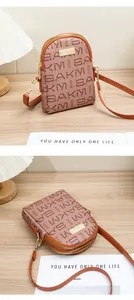 Detail of crossbody phone bag with double zipper and vintage letter print on brown texture