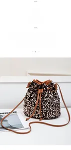 Détail du sac seau à paillettes bronze avec fermeture à cordon et fine bandoulière en cuir