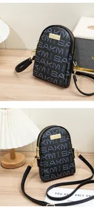 Close-up of leather crossbody phone bag with double zippers and gold metal hardware