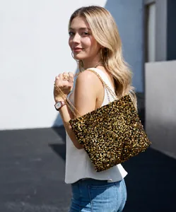 Fashionable tote bag with gold and black sequins and elegant metal chain strap shown on model