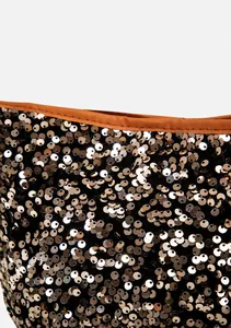 Detail of shimmering golden sequins on a black fabric base with premium leather trim