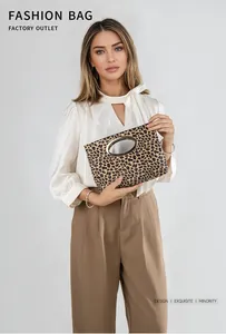 Dettaglio di pochette leopardata con un grande manico rotondo in metallo dorato