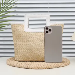 Mini hand-woven straw handbag with white leather handles and square cutout design