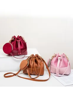 Detailed view of drawstring bucket bags in burgundy, brown and pink velvet texture