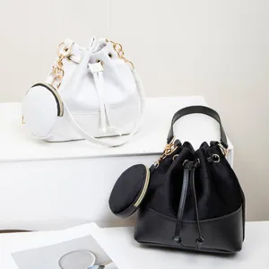 Chic suede bucket bags in black and white with gold chains and mini pouches