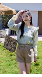 Chic female outfit featuring a sparkling gold sequin chain shoulder bag and lace blouse