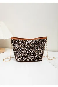 Detailed close-up of golden sequins on a black evening bucket bag with chain strap