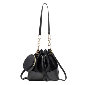 Chic black drawstring bucket bag set with suede panels and gold chain shoulder strap