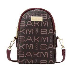 Brown monogram crossbody phone bag with burgundy trim and golden metal plate detail