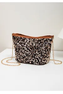 Detailed close-up of rose gold sequins on bucket bag with a gold chain strap