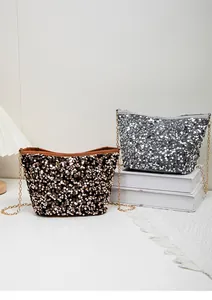 Close-up of sparkling sequin bucket bags with metal chains in black and silver colors