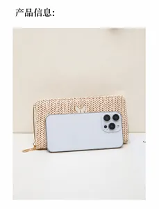 Comparación de tamaño de cartera beige de paja con dije de mariposa y smartphone