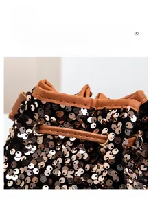 Détail d'un sac seau noir avec paillettes dorées et cordon de serrage en cuir marron
