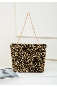 Detail of shimmering gold and black sequins on a chic tote bag with golden chain strap