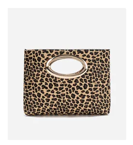 Dettaglio della pochette leopardata con manico ovale in metallo dorato su sfondo bianco