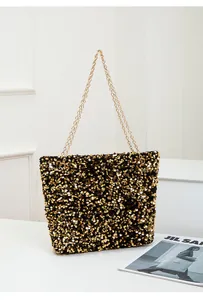 Detail of sequin shoulder bag with golden chain strap and shimmering black gold texture