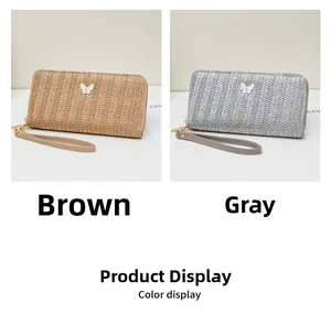 Detalle de carteras largas con textura de paja en marrón y gris con dijes de mariposa