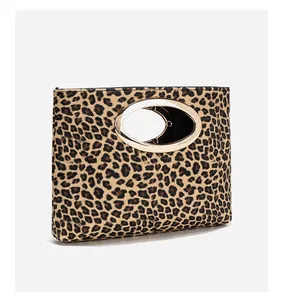 Dettaglio della pochette leopardata alla moda con manico ovale in metallo dorato lucido