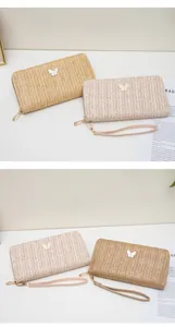 Detalle de carteras tipo sobre de paja tejida con dijes de mariposa y correas de cuero