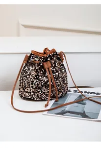 Détail du sac seau à paillettes avec cordon de serrage marron et paillettes dorées polies