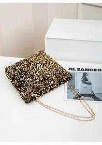 Detailed view of the sparkling black and gold sequins texture on this stylish chain bag