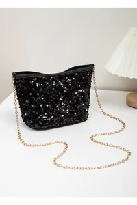 Detailed close-up of shimmering black sequins and gold chain strap on small bucket bag