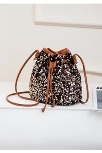 Détail du sac seau à paillettes bronzes avec bordure en similicuir marron et cordon