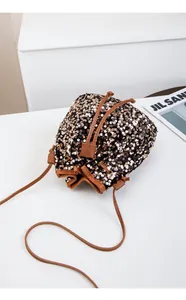 Vue de dessus d'un sac seau à paillettes or rose avec cordon de serrage et bandoulière