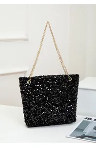 Detail of shimmering black sequins and elegant gold chain strap on shoulder bag