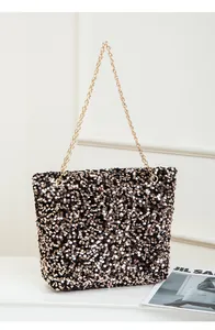 Detailed close-up of glittering black and gold sequins on a stylish chain shoulder bag