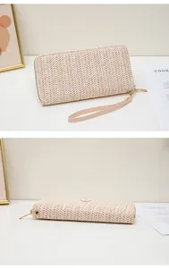 Detalle de billetera de paja tejida con cremallera dorada y correa de muñeca de PU