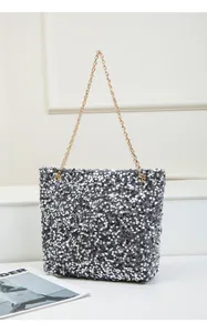Detail showing shiny silver sequins and gold chain strap on a trendy tote shoulder bag