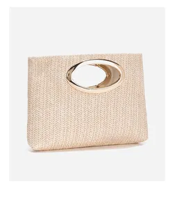 Dettaglio pochette intrecciata beige minimalista con elegante manico in metallo dorato