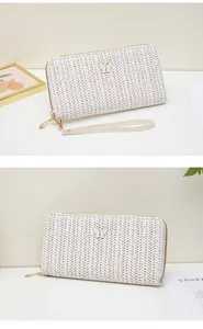 Detalle de cartera tejida larga con adorno de mariposa 3D y cremallera dorada fina