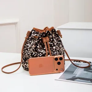 Sac seau chic à paillettes or rose avec bandoulière en cuir marron et cordon serrage