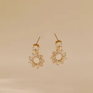 Macro detail of 18K gold plated flower earrings featuring marquise-cut cubic zirconia crystals