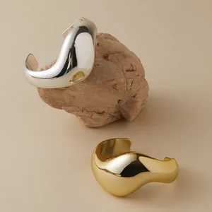Detailopname van een bohemien onregelmatige metalen armband in goud en zilver op steen
