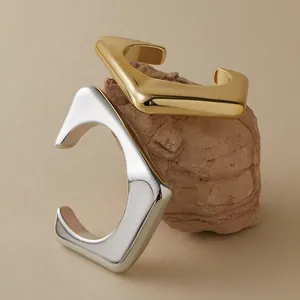 Macro-opname van goud en zilver geometrische open armbanden op een ruwe stenen