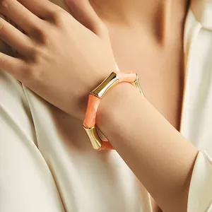 Bracciale rigido in acrilico stile bambù con trama marmo arancio e inserti dorati