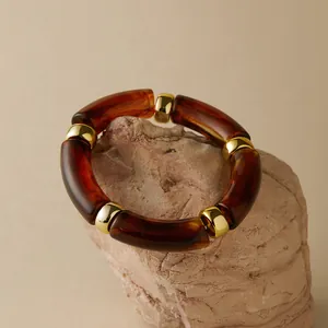 Detailaufnahme von böhmischem Harz-Armband mit goldenen Trennelementen auf Naturstein