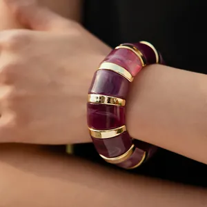 Close-up of chunky bohemian resin bracelet with purple marbled texture and gold metal stripes