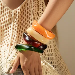 Set of four chunky translucent acrylic bangles in amber, green, cream and orange marble tones