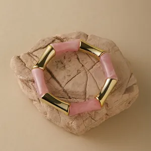 Dettaglio del bracciale a bambù in acrilico rosa marmorizzato con sezioni dorate