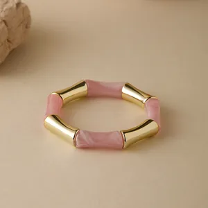 Dettaglio del bracciale a bambù con metallo dorato e resina marmorizzata rosa