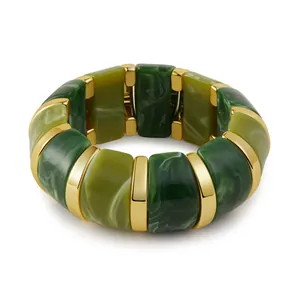 Close-up of green marble resin blocks and polished gold metal spacers on stretch bracelet