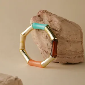 Dettaglio di un bracciale stile bambù con segmenti in acrilico colorato e giunti dorati