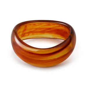 Macro detail of Bohemian resin bangle showing marbled amber texture and polished finish