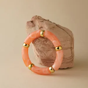 Detail von rosa marmorierten Harzgliedern und Goldperlen am böhmischen Stretcharmband